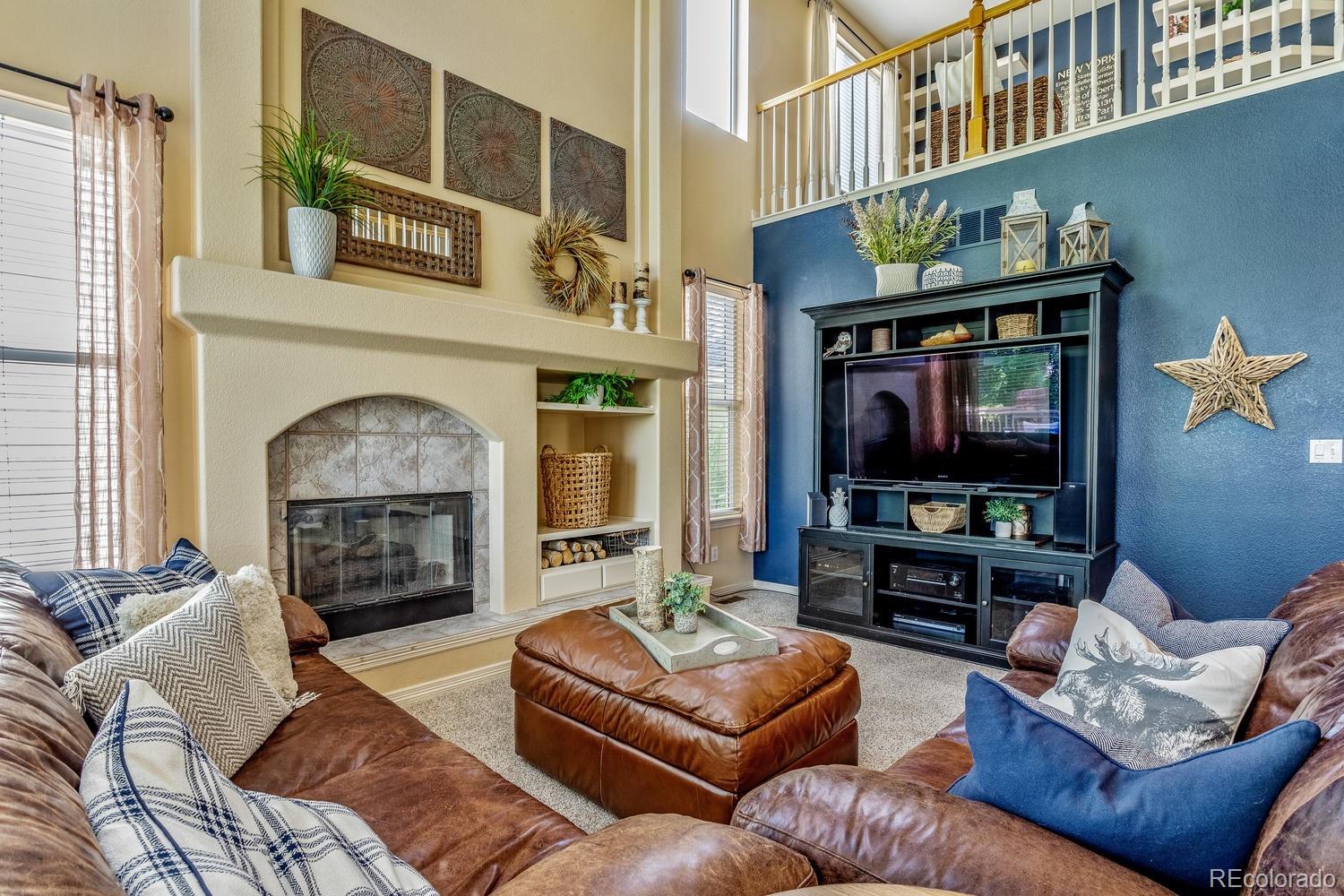 6966 South Riviera Street Aurora, CO 80016 - Photo 11 of 30 a living room with furniture a fireplace and a flat screen tv