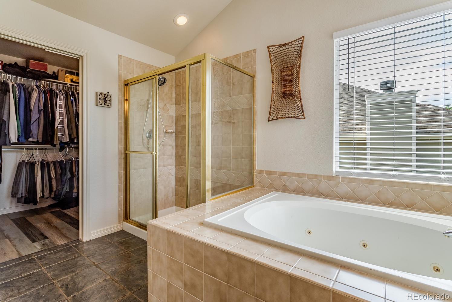 6966 South Riviera Street Aurora, CO 80016 - Photo 18 of 30 a bathroom with a tub and a shower