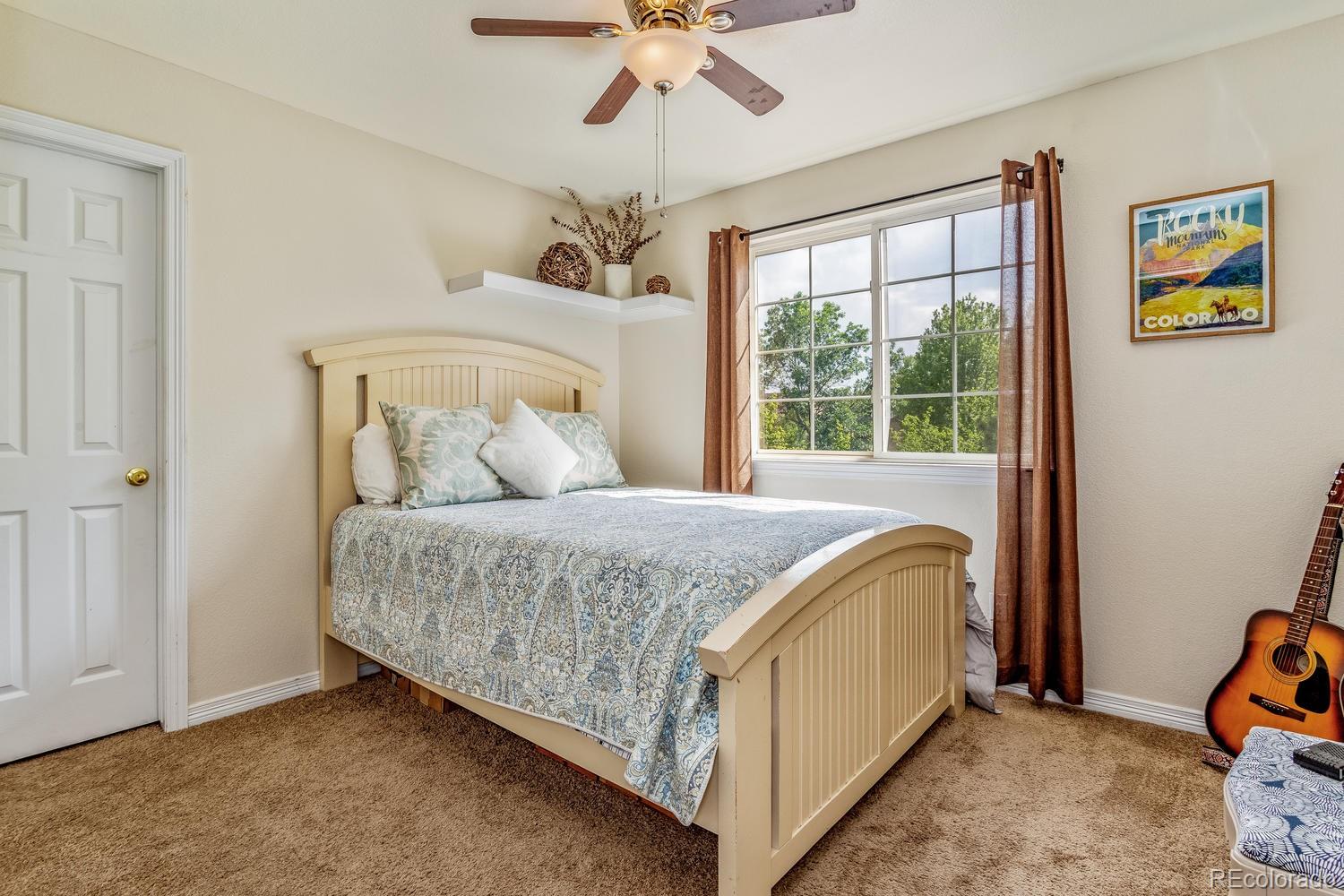 6966 South Riviera Street Aurora, CO 80016 - Photo 19 of 30 a bedroom with a bed and a window