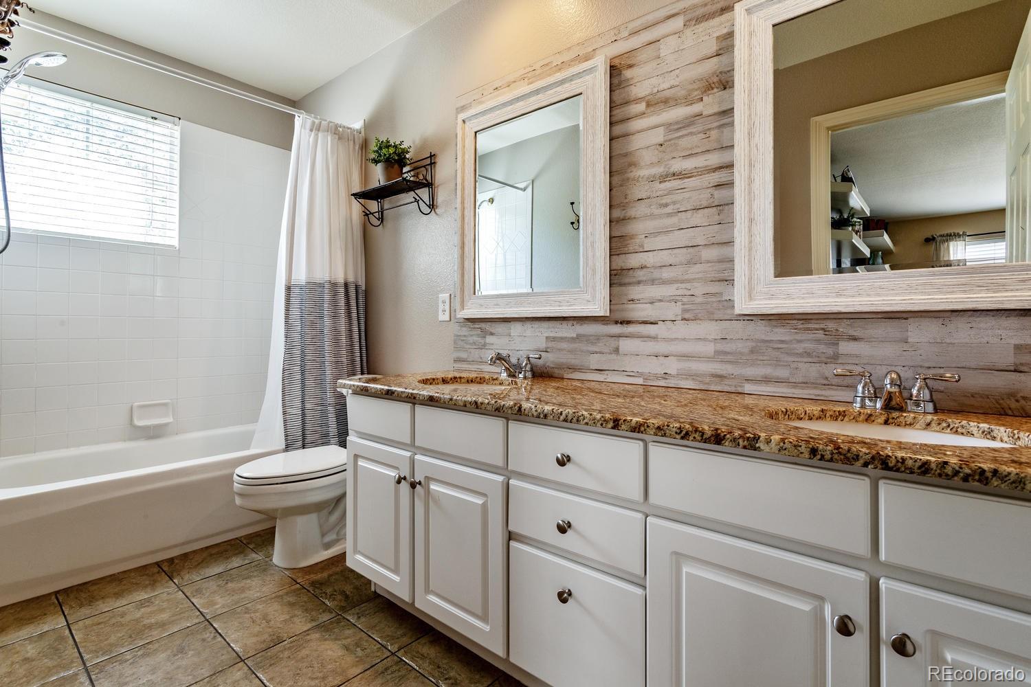 6966 South Riviera Street Aurora, CO 80016 - Photo 20 of 30 a bathroom with a granite countertop toilet sink and mirror