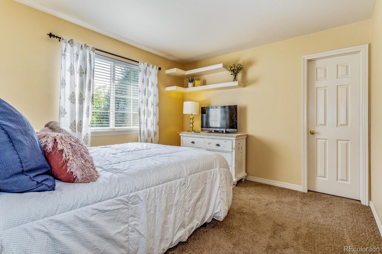 6966 South Riviera Street Aurora, CO 80016 - Photo 21 of 30 a bedroom with a bed and wooden floor