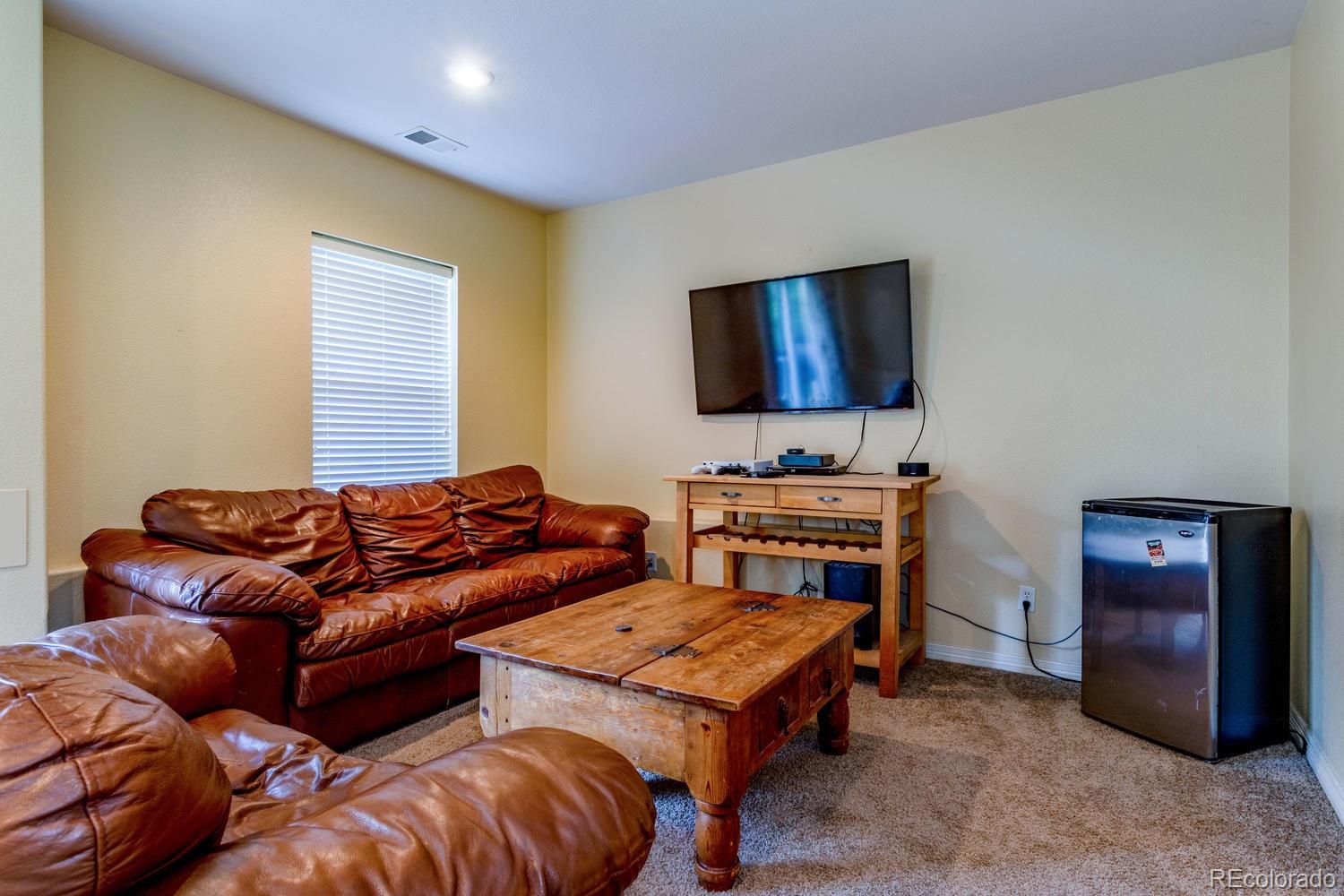 6966 South Riviera Street Aurora, CO 80016 - Photo 22 of 30 a living room with furniture and a flat screen tv