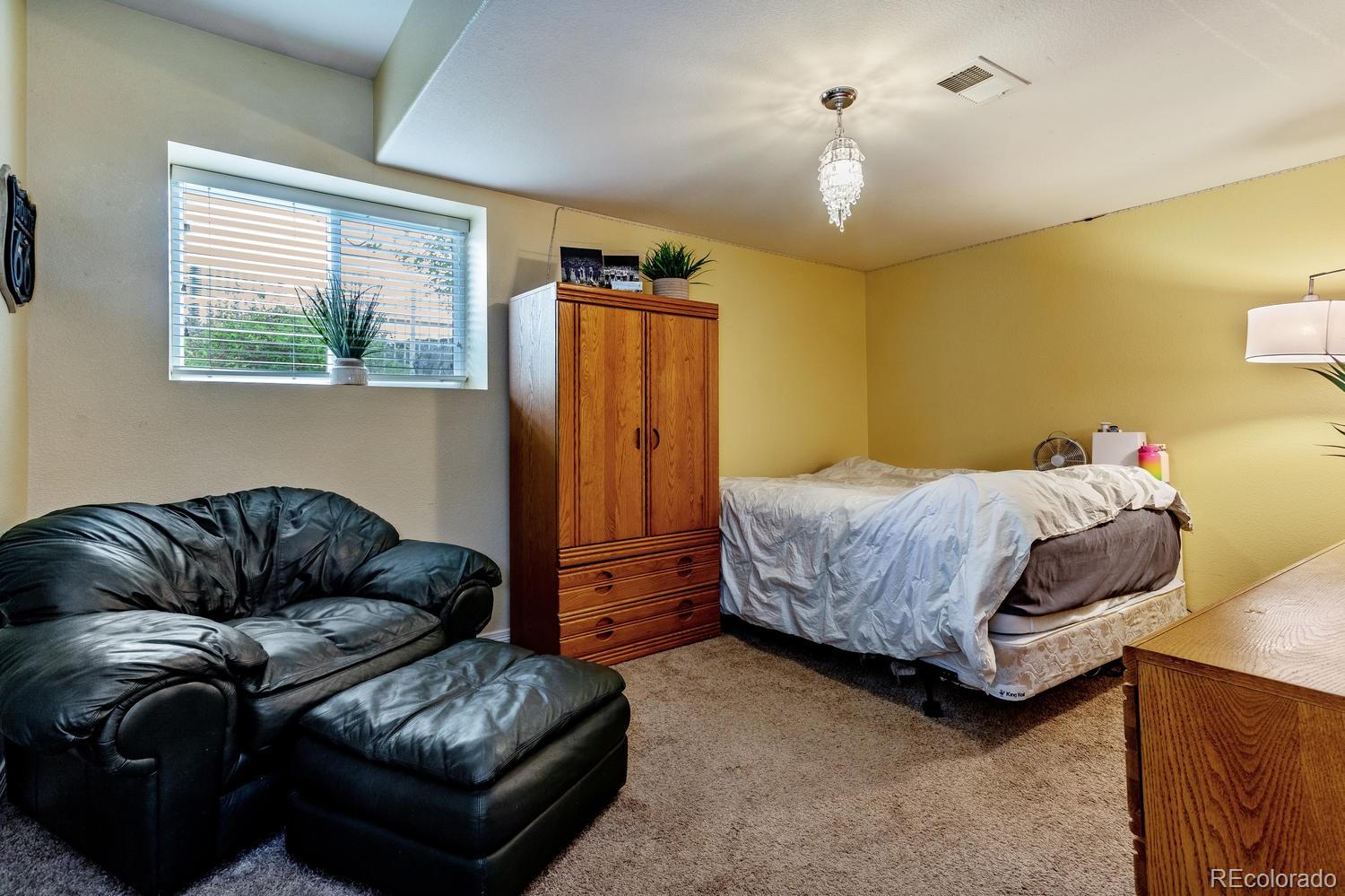 6966 South Riviera Street Aurora, CO 80016 - Photo 23 of 30 a bedroom with a bed couch and window
