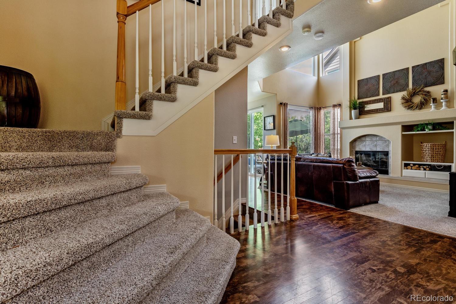 6966 South Riviera Street Aurora, CO 80016 - Photo 4 of 30 a living room with fireplace furniture and a chandelier