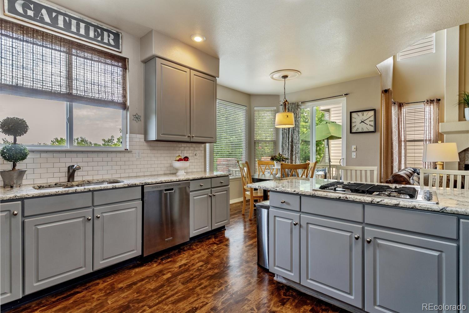 6966 South Riviera Street Aurora, CO 80016 - Photo 10 of 30 a kitchen with a sink cabinets and wooden floor