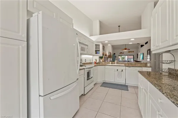 a kitchen with white cabinets and white appliances