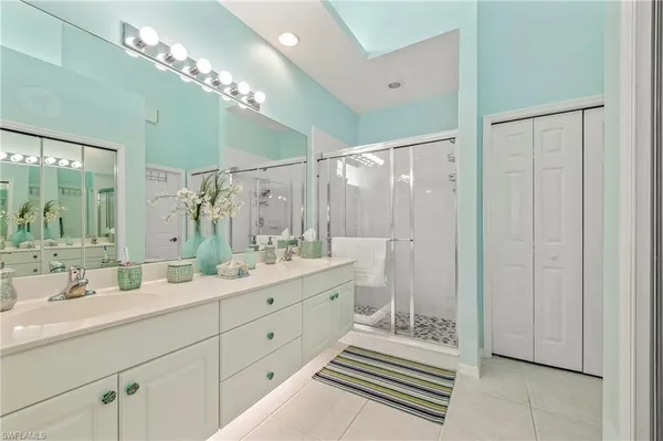 a bathroom with a double vanity sink mirror and shower