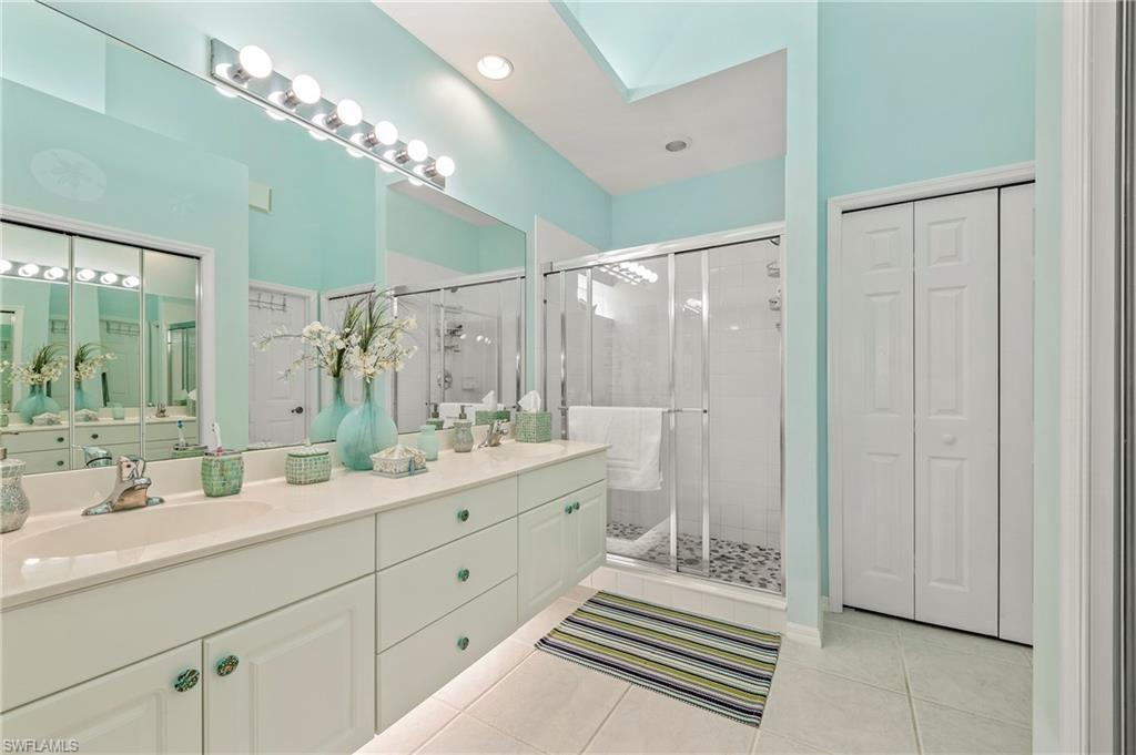 2381 Hidden Lake Court, Unit 12 Naples, FL 34112 - Photo 25 of 34 a bathroom with a double vanity sink mirror and shower