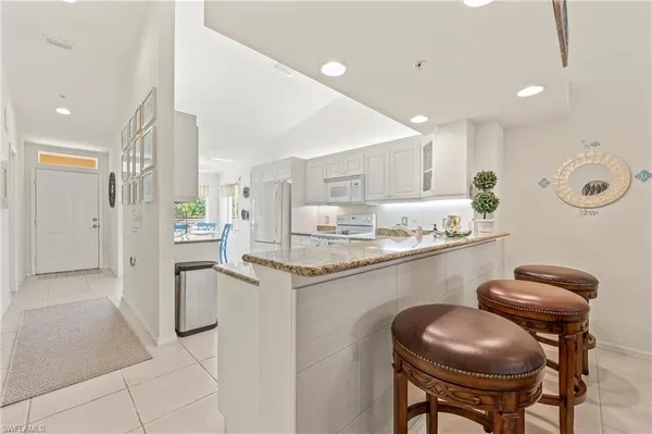 a kitchen with stainless steel appliances granite countertop a sink and a refrigerator