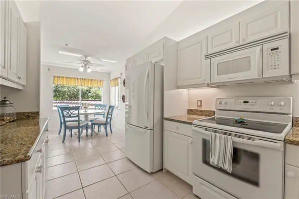 a kitchen with granite countertop a stove cabinets and refrigerator