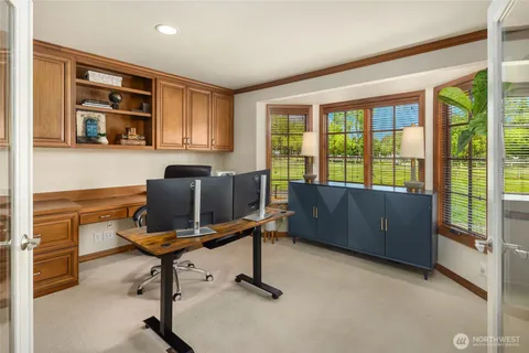 a view of a workspace with furniture and a window