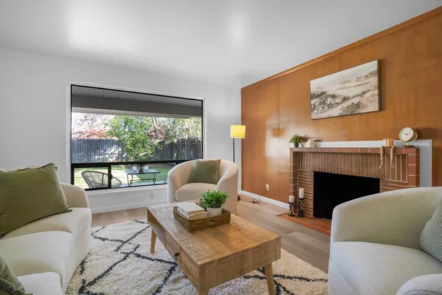 a living room with furniture a fireplace and a large window