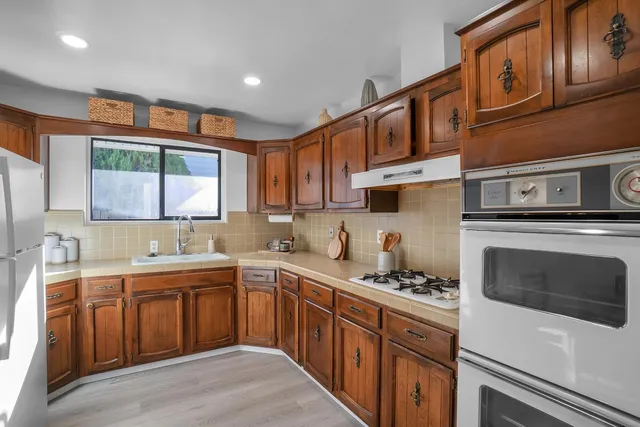 a kitchen with stainless steel appliances granite countertop a sink stove and cabinets