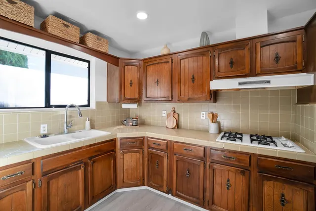 a kitchen with stainless steel appliances granite countertop a sink stove cabinets and wooden floor
