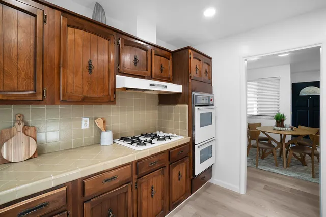 a kitchen with stainless steel appliances granite countertop a sink stove and cabinets