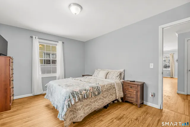 a bedroom with a bed and wooden floor