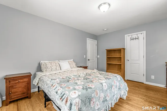 a bedroom with a bed and wooden floor
