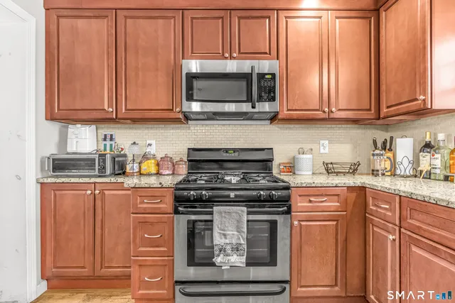 a kitchen with stainless steel appliances granite countertop a stove and a microwave