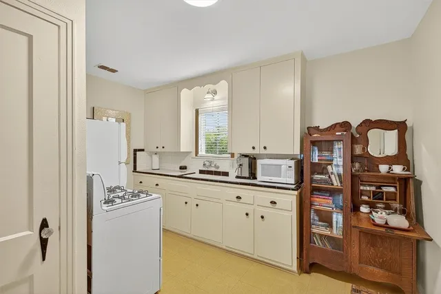 a view of a kitchen with cabinets and wooden floor