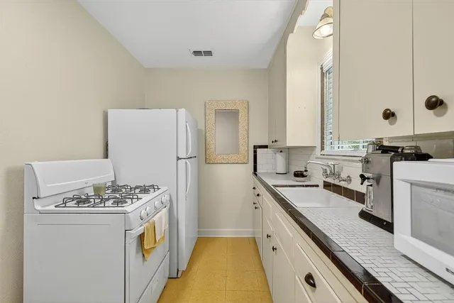 a kitchen with a sink stove and refrigerator