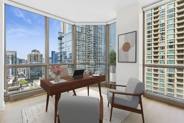 a view of a workspace with furniture and a window