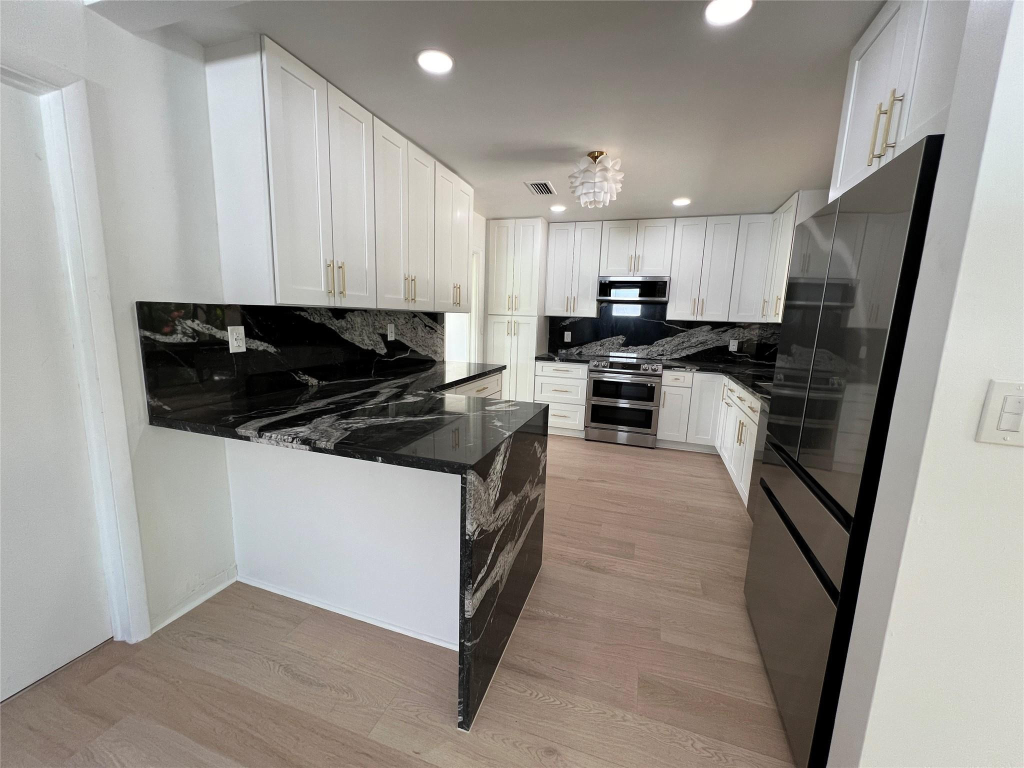 4408 Monroe Street Hollywood, FL 33021 - Photo 11 of 26 a kitchen with stainless steel appliances a stove a sink a microwave a refrigerator and cabinets