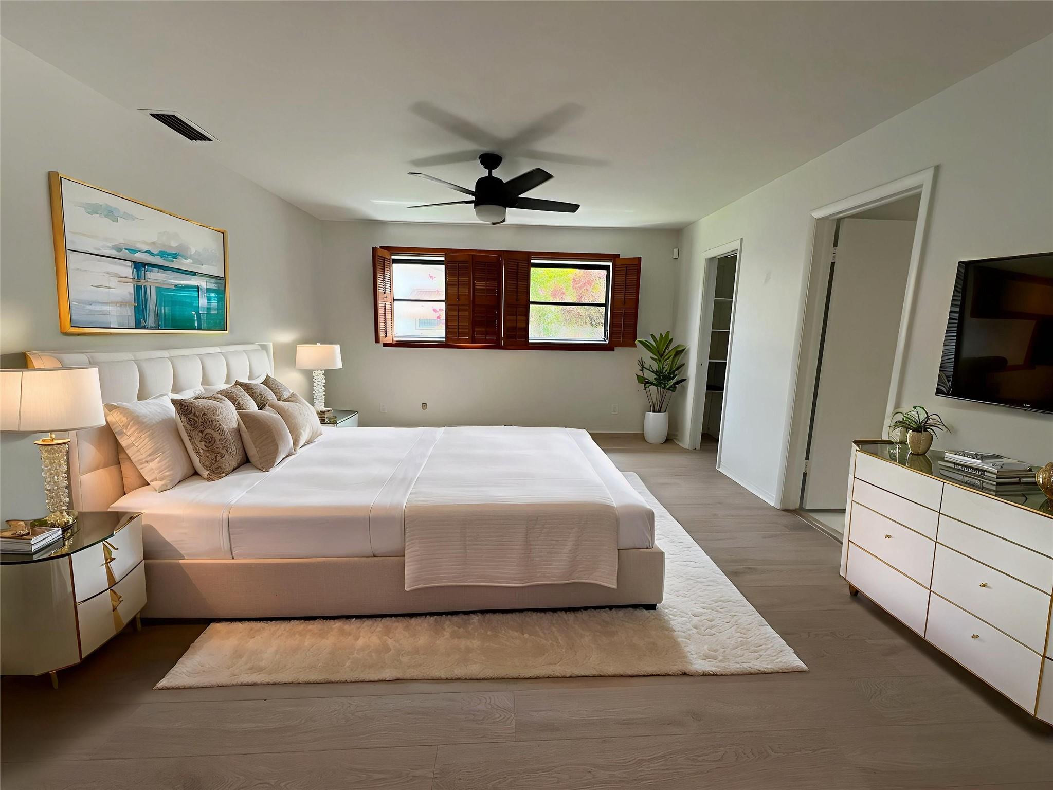 4408 Monroe Street Hollywood, FL 33021 - Photo 12 of 26 a spacious bedroom with a bed and a flat screen tv