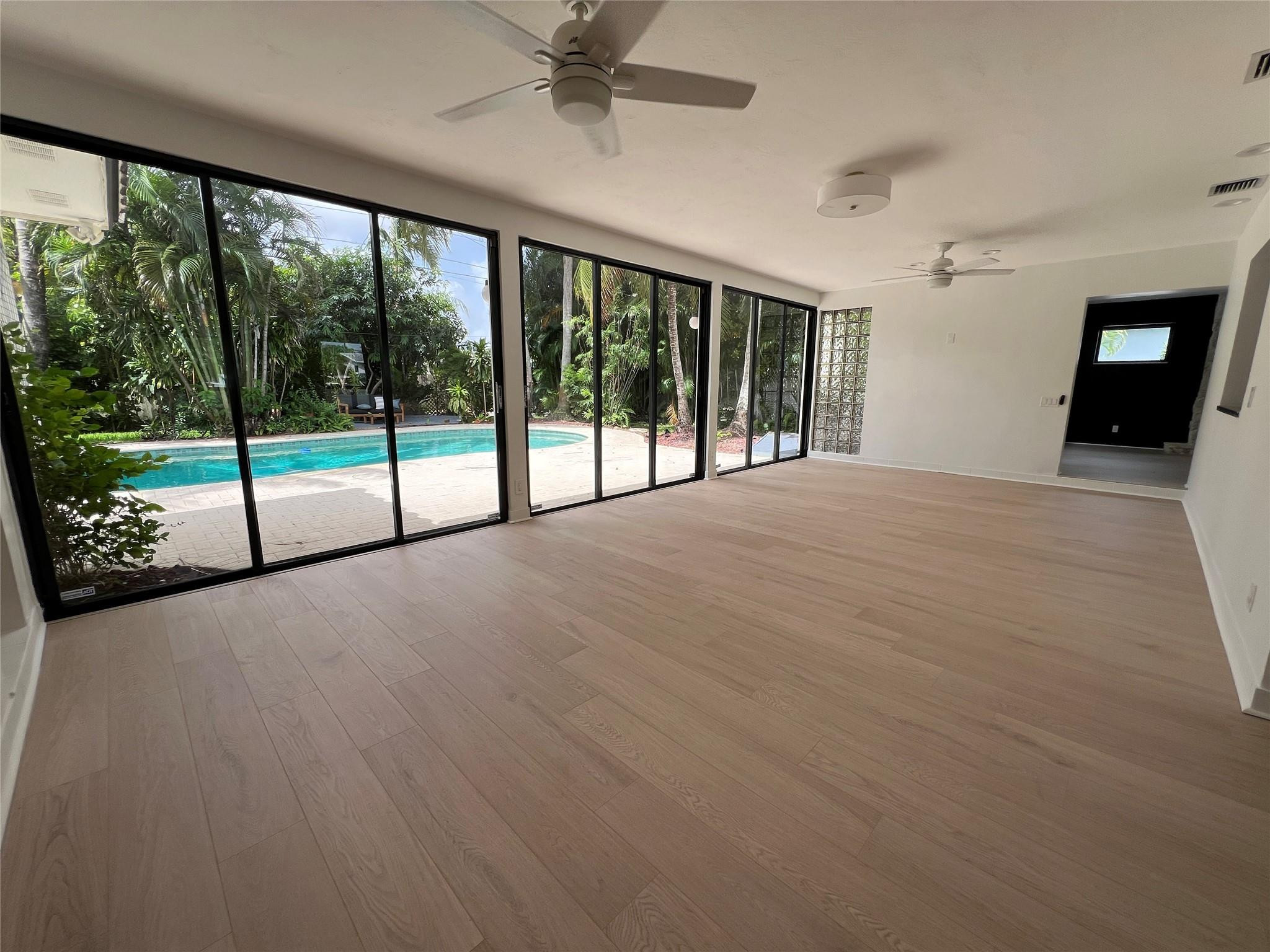4408 Monroe Street Hollywood, FL 33021 - Photo 18 of 26 a view of an empty room with wooden floor and a ceiling fan