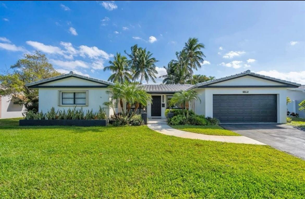 4408 Monroe Street Hollywood, FL 33021 - Photo 2 of 26 a front view of a house with a yard and garage