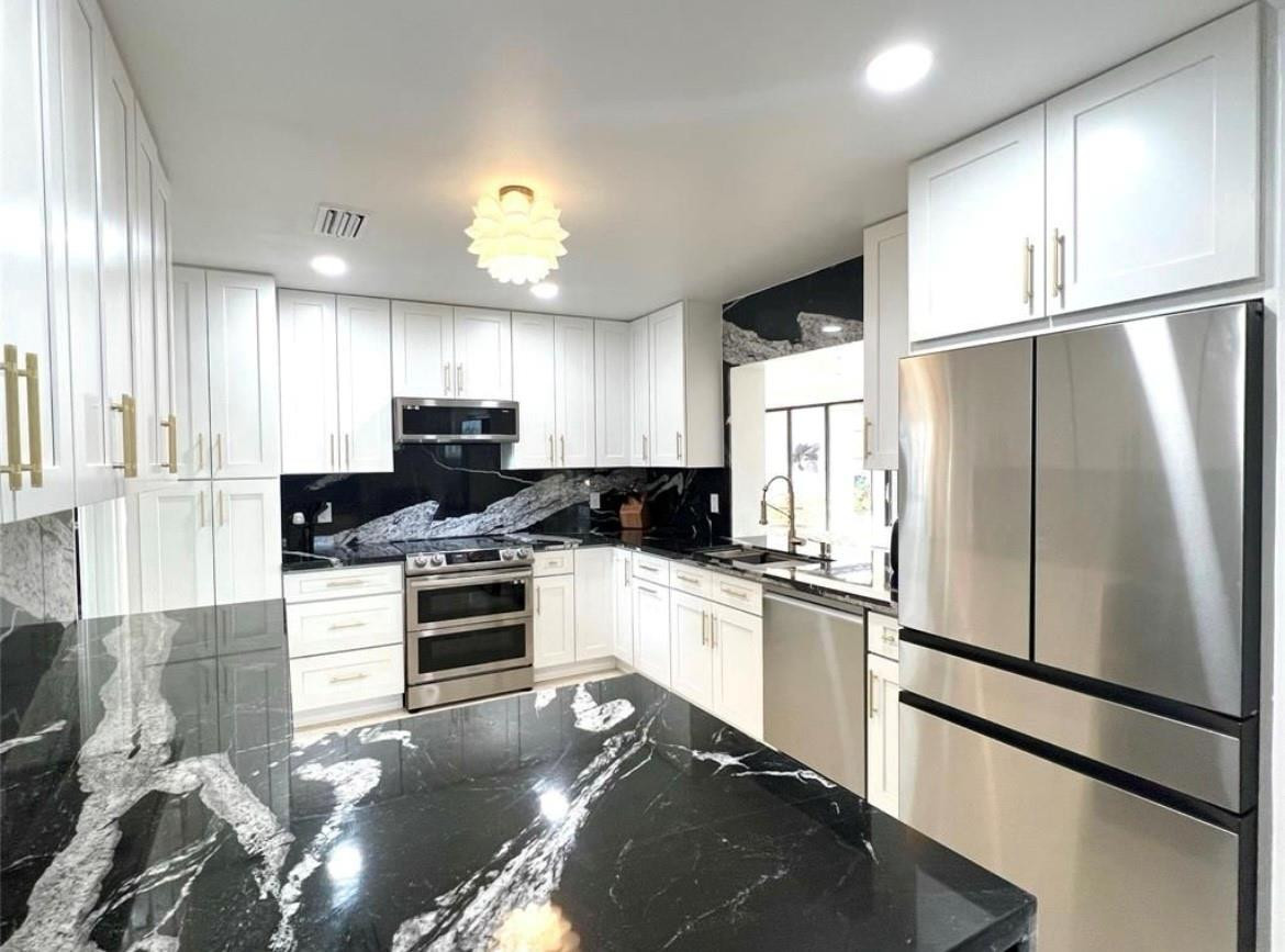 4408 Monroe Street Hollywood, FL 33021 - Photo 7 of 26 a kitchen with stainless steel appliances granite countertop a refrigerator a stove a sink and a microwave