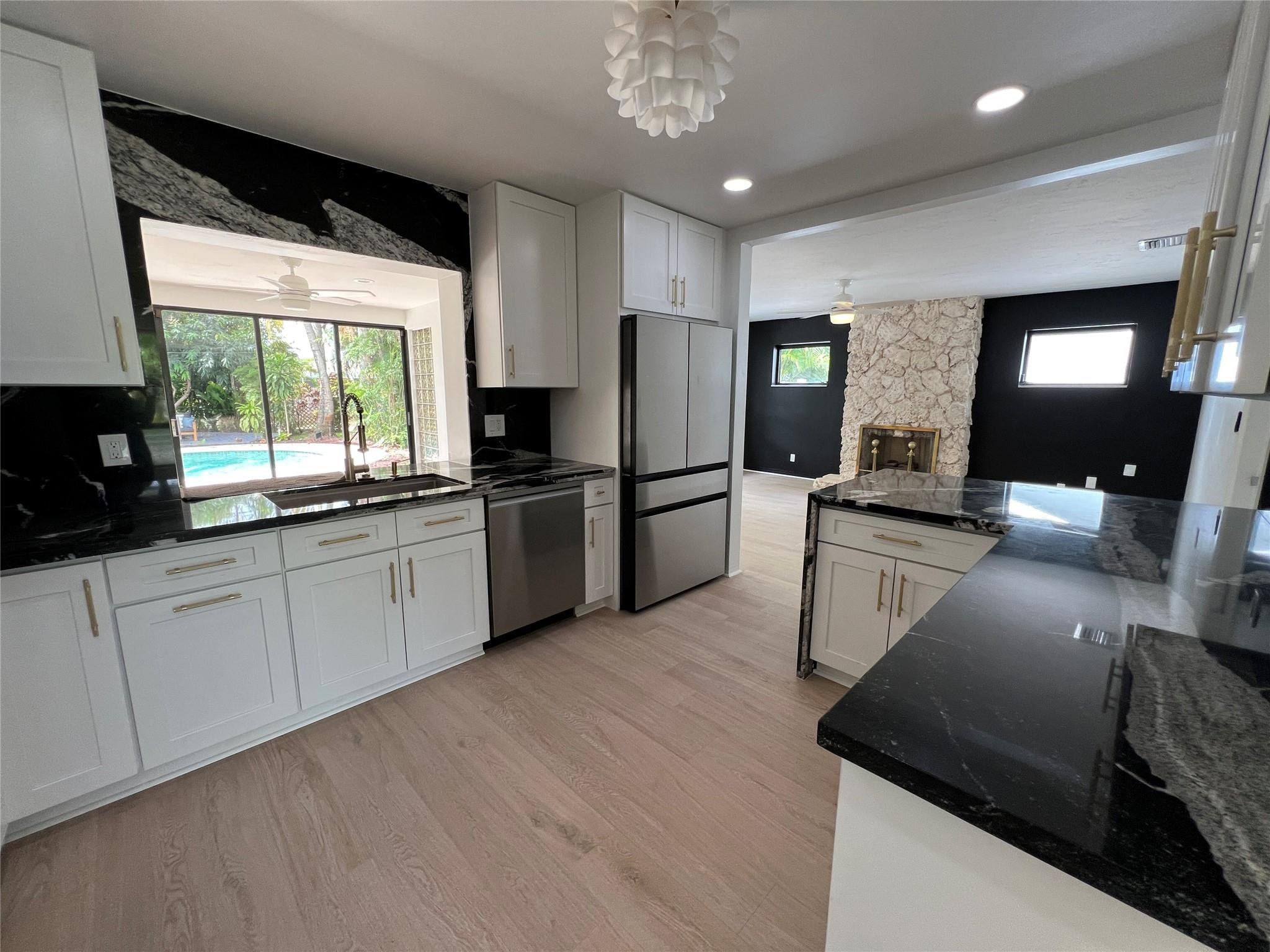 4408 Monroe Street Hollywood, FL 33021 - Photo 9 of 26 a kitchen with stainless steel appliances granite countertop a sink refrigerator and microwave