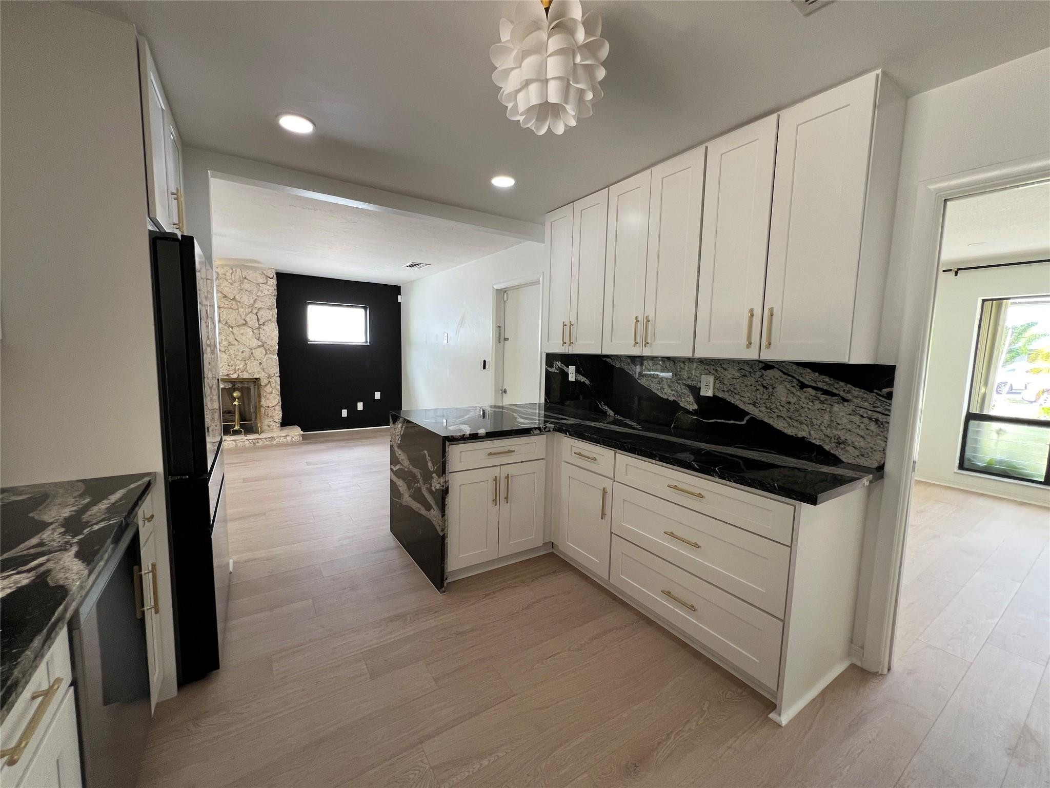 4408 Monroe Street Hollywood, FL 33021 - Photo 10 of 26 a kitchen with granite countertop white cabinets and black appliances