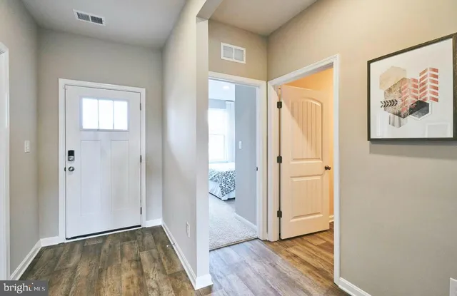 a view of a hallway with wooden floor and door