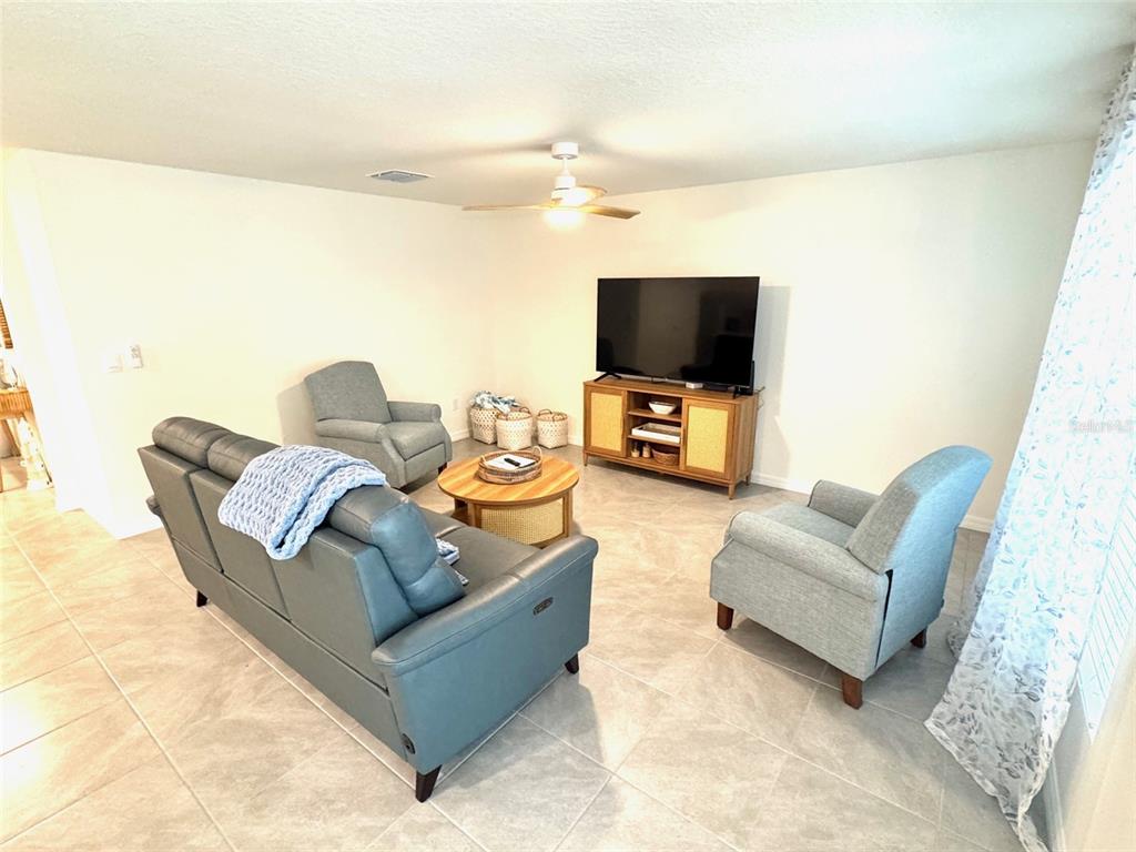 13374 Mylion Way Spring Hill, FL 34610 - Photo 11 of 39 a living room with furniture and a flat screen tv