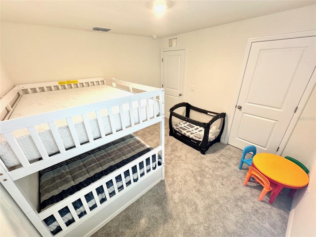 13374 Mylion Way Spring Hill, FL 34610 - Photo 26 of 39 a bedroom with furniture and a wooden floor