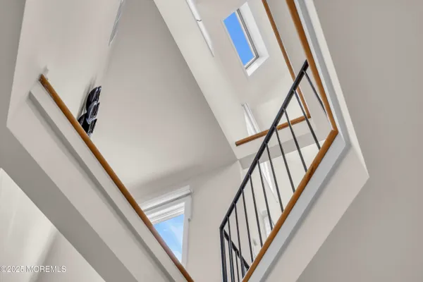 a view of staircase with railing and white walls