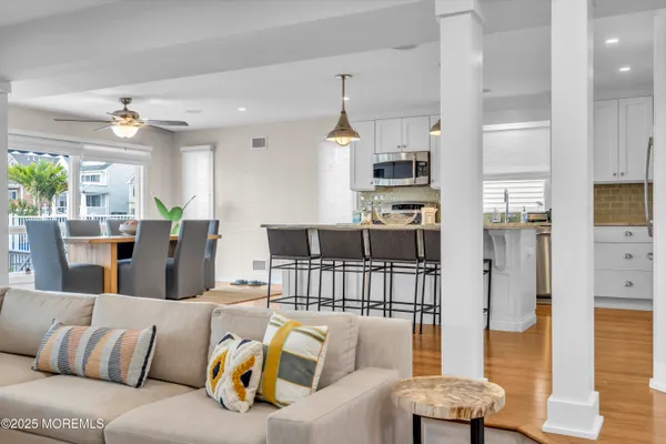 a living room with furniture kitchen view and a chandelier