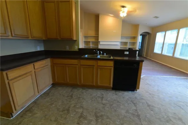 a kitchen with granite countertop a sink and cabinets