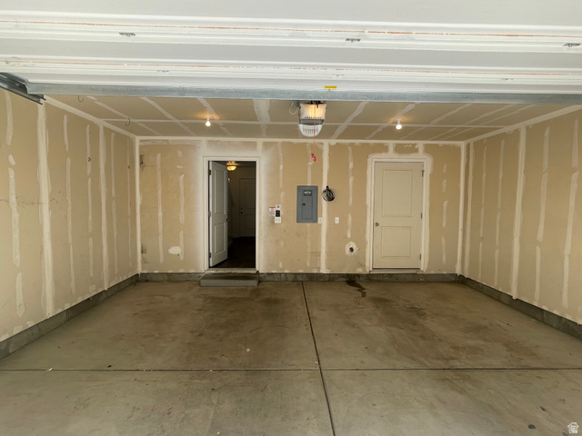 14760 Rising Star Way, Unit 71 Bluffdale, UT 84065 - Photo 40 of 41 Spacious garage with concrete flooring, exposed drywall, two panel doors, and overhead lighting