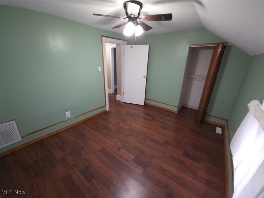30 Medina Street Rittman, OH 44270 - Photo 21 of 28 Unfurnished bedroom with dark wood-style flooring, a ceiling fan, vaulted ceiling, and a closet