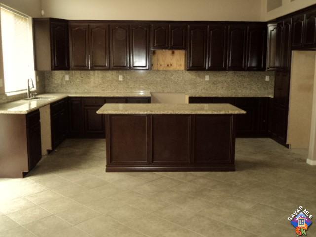 5753 Monaco Drive Palmdale, CA 93552 - Photo 7 of 29 a kitchen with stainless steel appliances granite countertop wooden cabinets a stove top oven a sink and dishwasher
