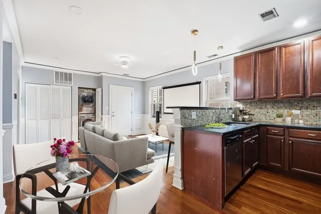 a kitchen with granite countertop a sink cabinets and wooden floor