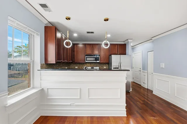 a kitchen with stainless steel appliances granite countertop a refrigerator and a stove