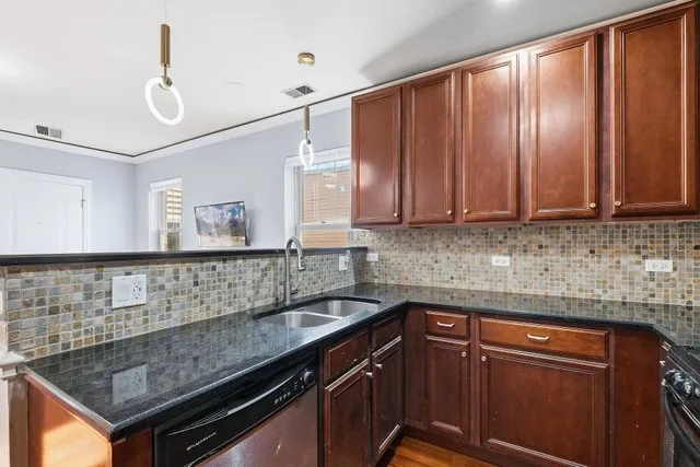 a kitchen with stainless steel appliances granite countertop wooden cabinets a sink and dishwasher