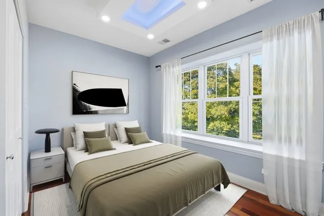 a bedroom with a large bed and a flat tv screen on a dresser