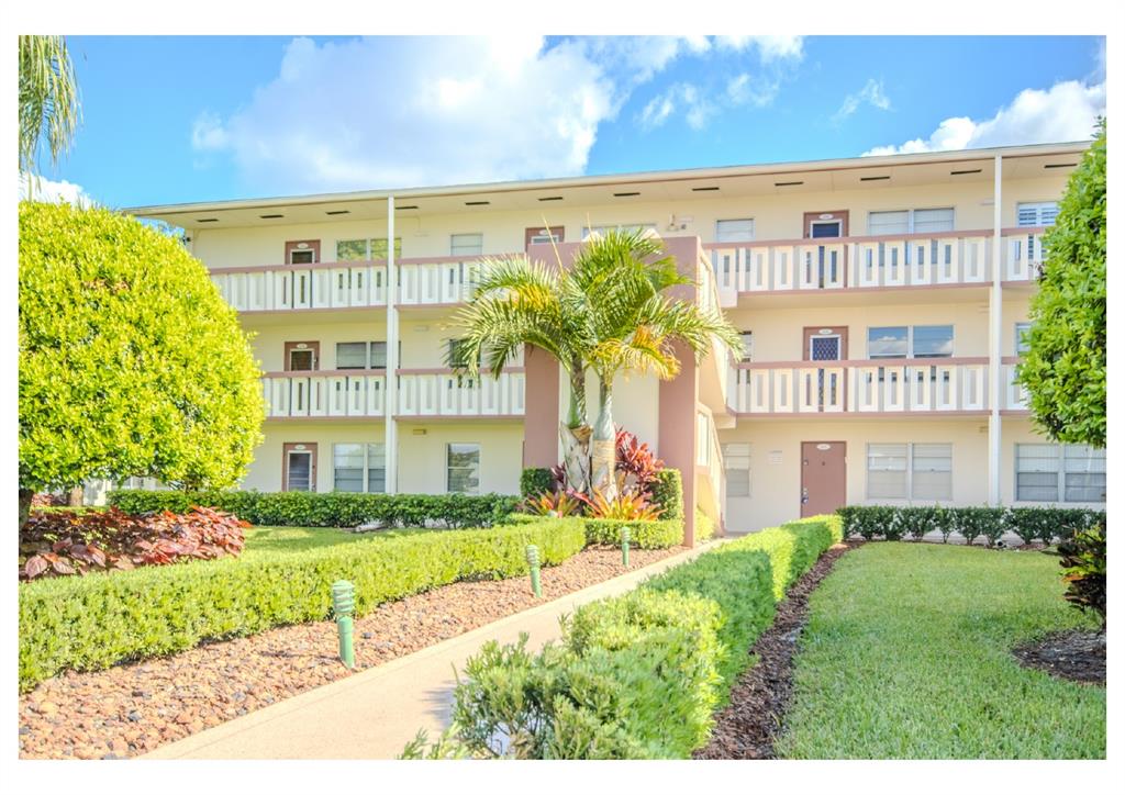 251 Preston F, Unit 251 Boca Raton, FL 33434 - Photo 31 of 35 a front view of a building with a garden and plants