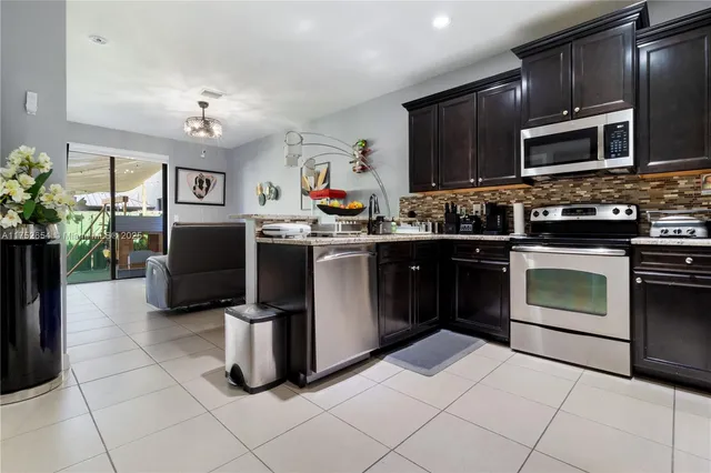 a kitchen with granite countertop a sink stainless steel appliances and cabinets
