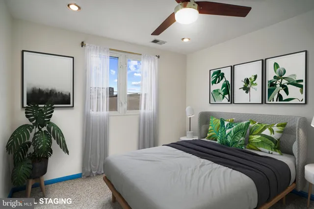 a bedroom with a bed and a potted plant