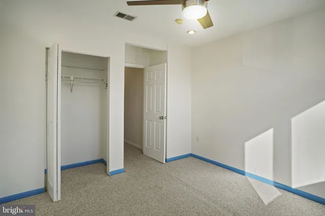 a view of an empty room with a ceiling fan