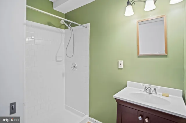 a bathroom with a sink vanity and shower